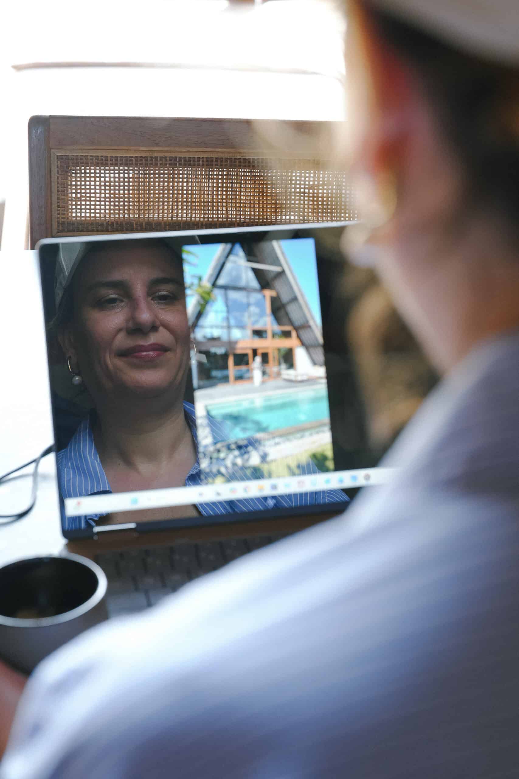 Over-the-shoulder view of a student watching a Business S’park Starter video lesson with Sophia Benarafa on a laptop