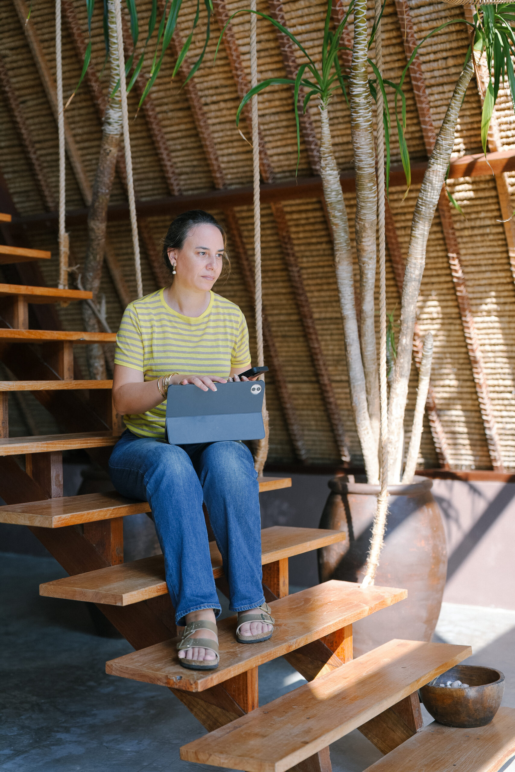 Sophia Benarafa sitting on wooden steps with a tablet, reviewing a client business plan