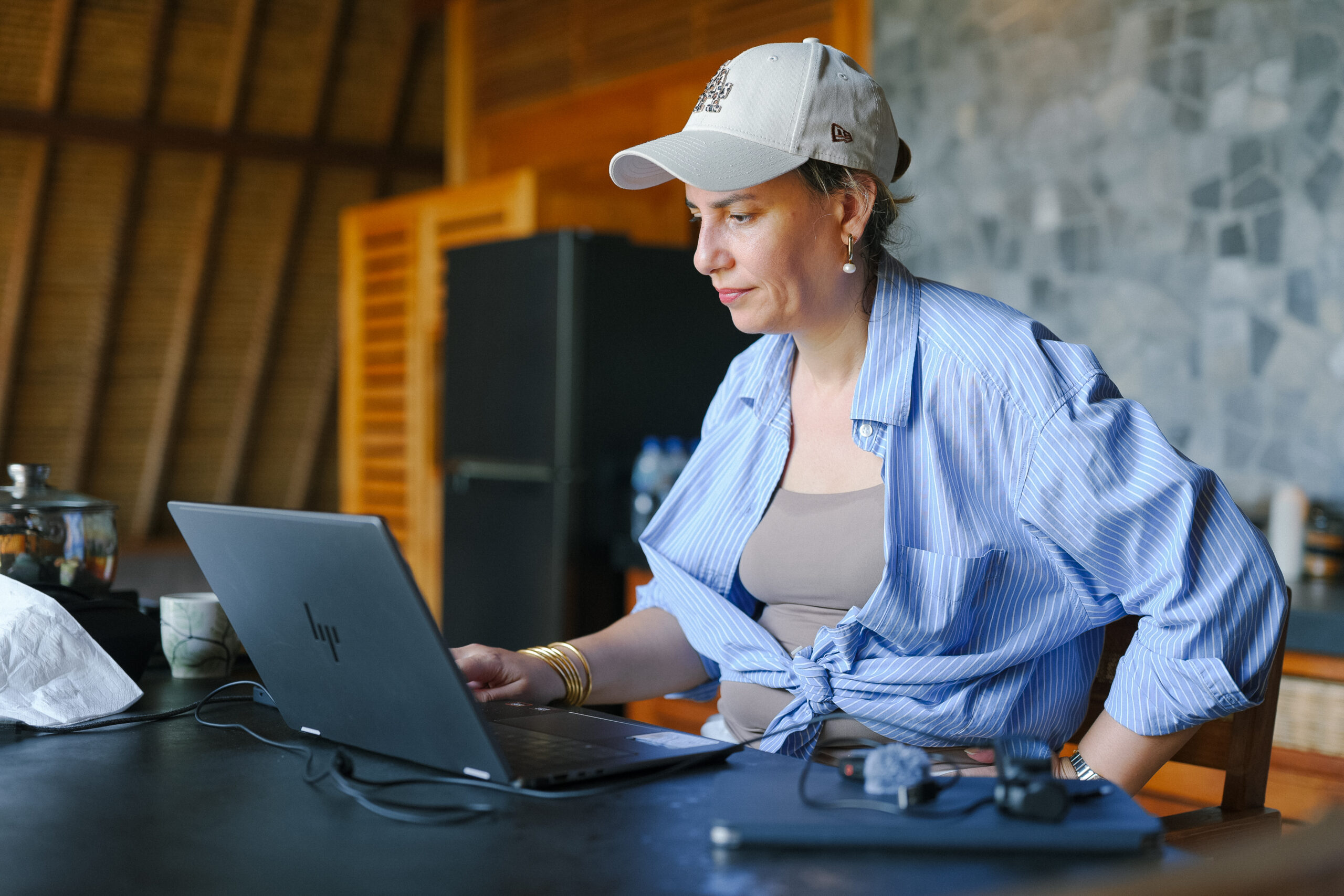 Sophia Benarafa, founder of The Academy by Sophia, working on her laptop in an open-air studio while running her business remotely