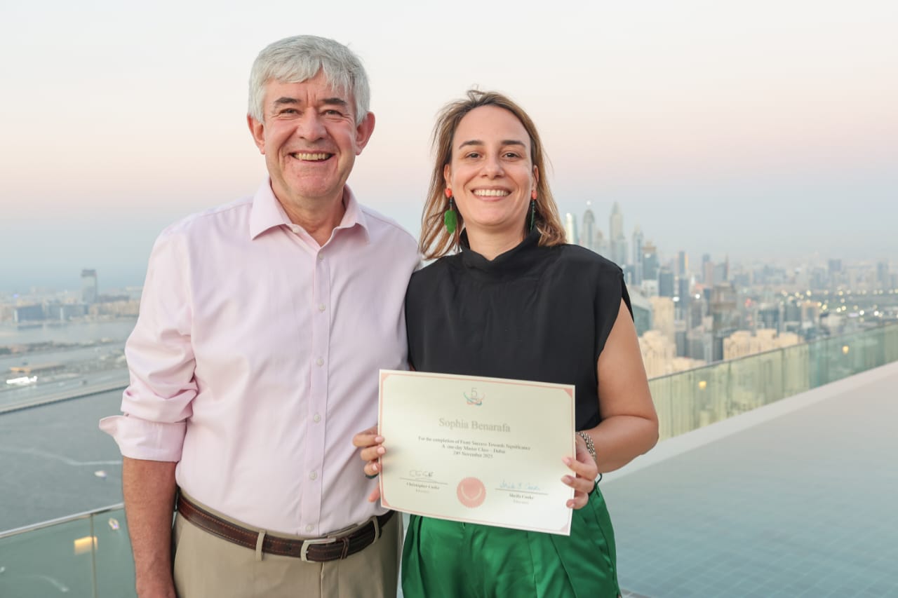 Sophia Benarafa receiving her From Success Towards Significance master class certificate on a Dubai rooftop overlooking the Marina skyline